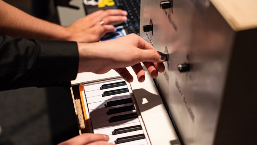 hands adjusting dials on a piano