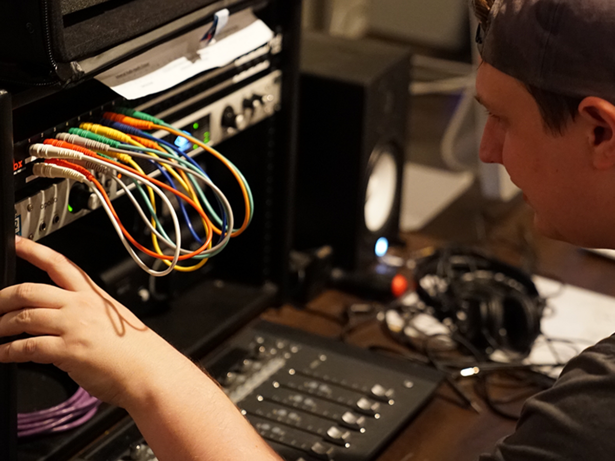 student adjusting wires on sound board
