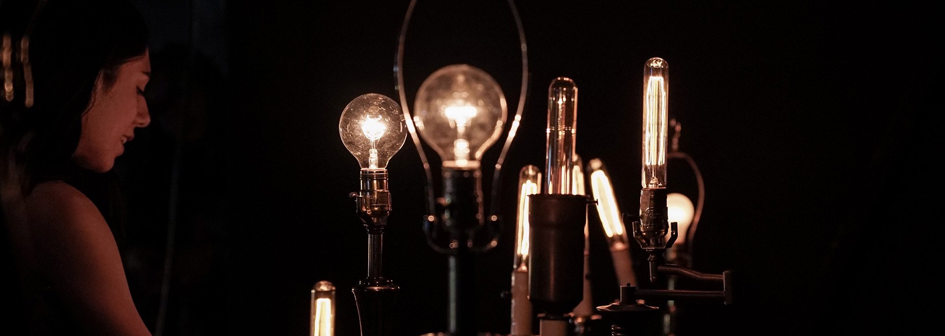 Student looking at an art installation with light bulbs