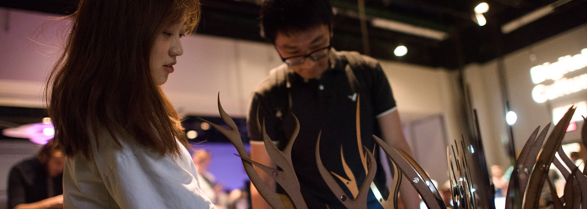 Two students viewing a laser cut art display